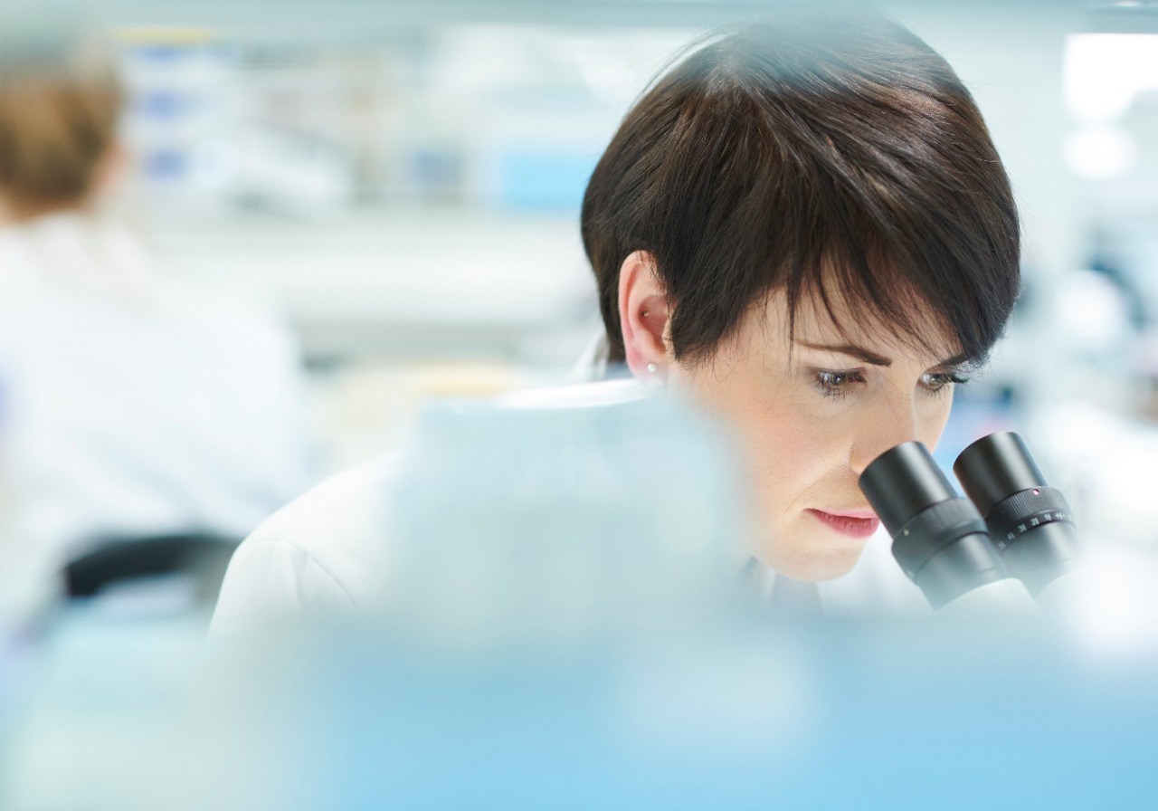female scientist in a busy research lab